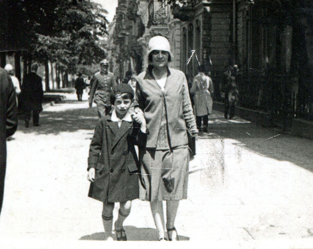 Chłopiec około 9 lat i kobieta w średnim wieku, idący ulicą obok siebie, trzymając się za ręce