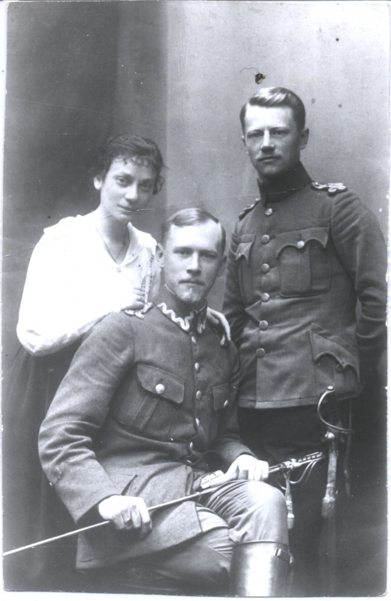 Trzy młode osoby: kobieta i dwaj żołnierze w mundurach; z podobieństwa widać, że to bracia