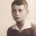 Popiersie chłopca około 12 lat, w ujęciu ¾ ku lewej, patrzącego w lewo z zamyśloną miną