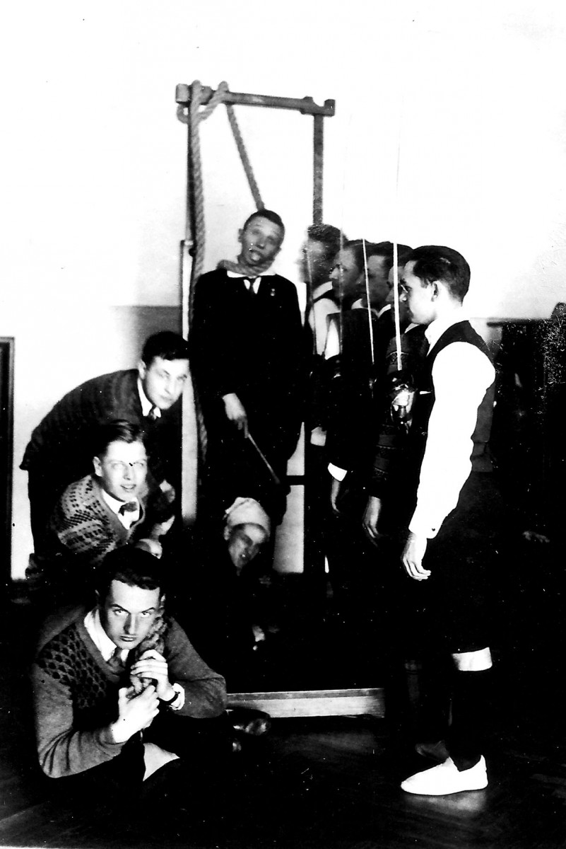 Grupa chłopców przy sztucznej szubienicy z kolegą udającym wisielca. Czterej z prawej ze szpadami