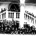 Kilkudziesięciu chłopców w mundurkach szkolnych i harcerskich na schodach z renesansową balustradą
